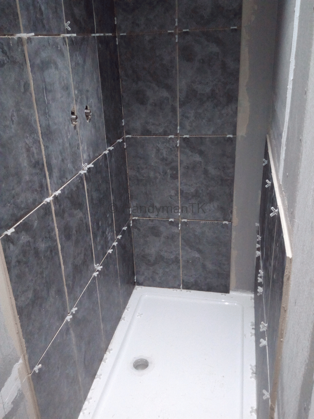 Handyman tiling shower room wall and floor